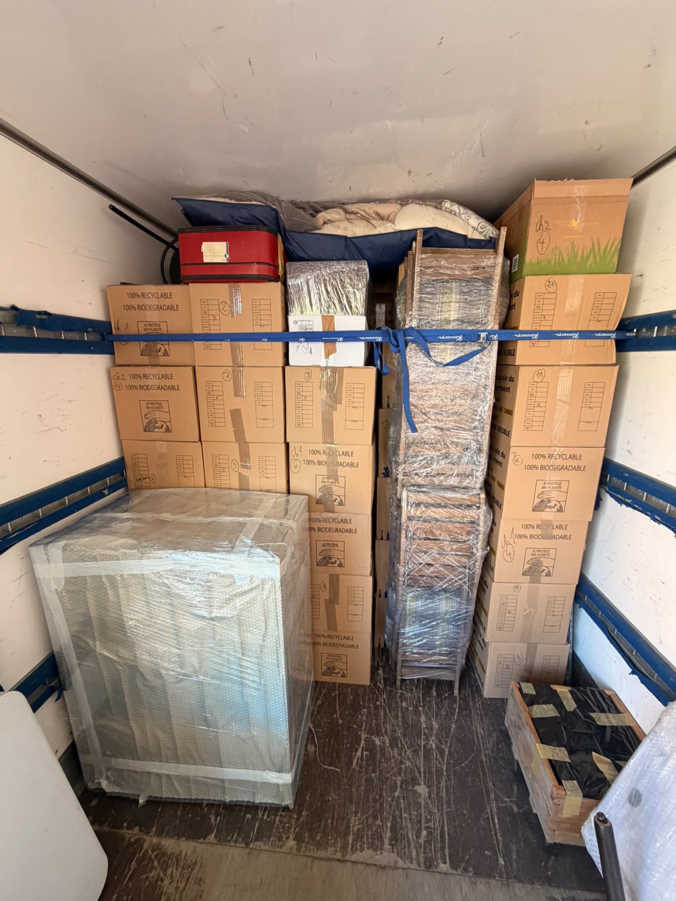 Cartons empilés et maintenus par des sangles dans un camion