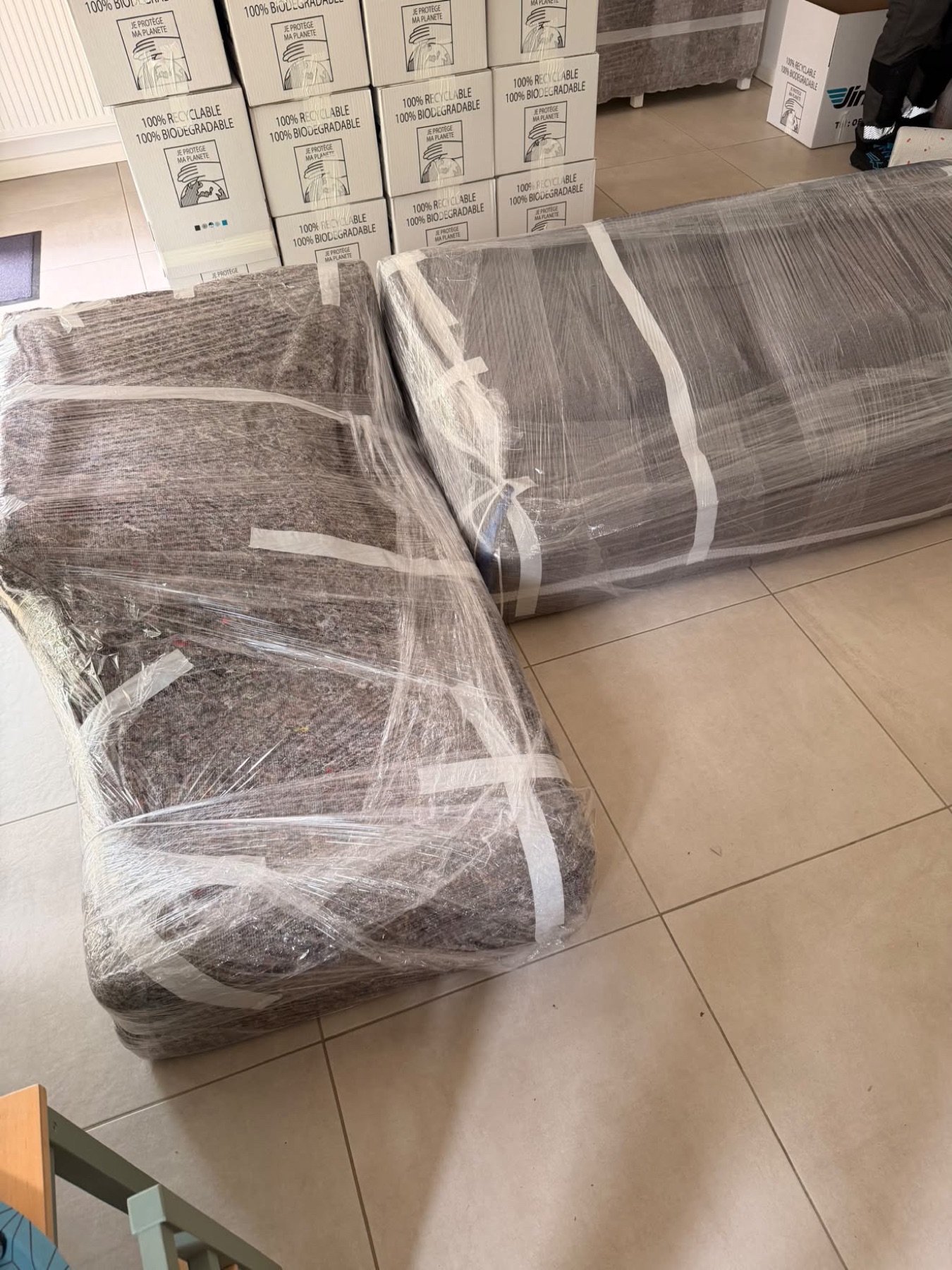 Éléments de canapé sous couvertures devant un mur de cartons
