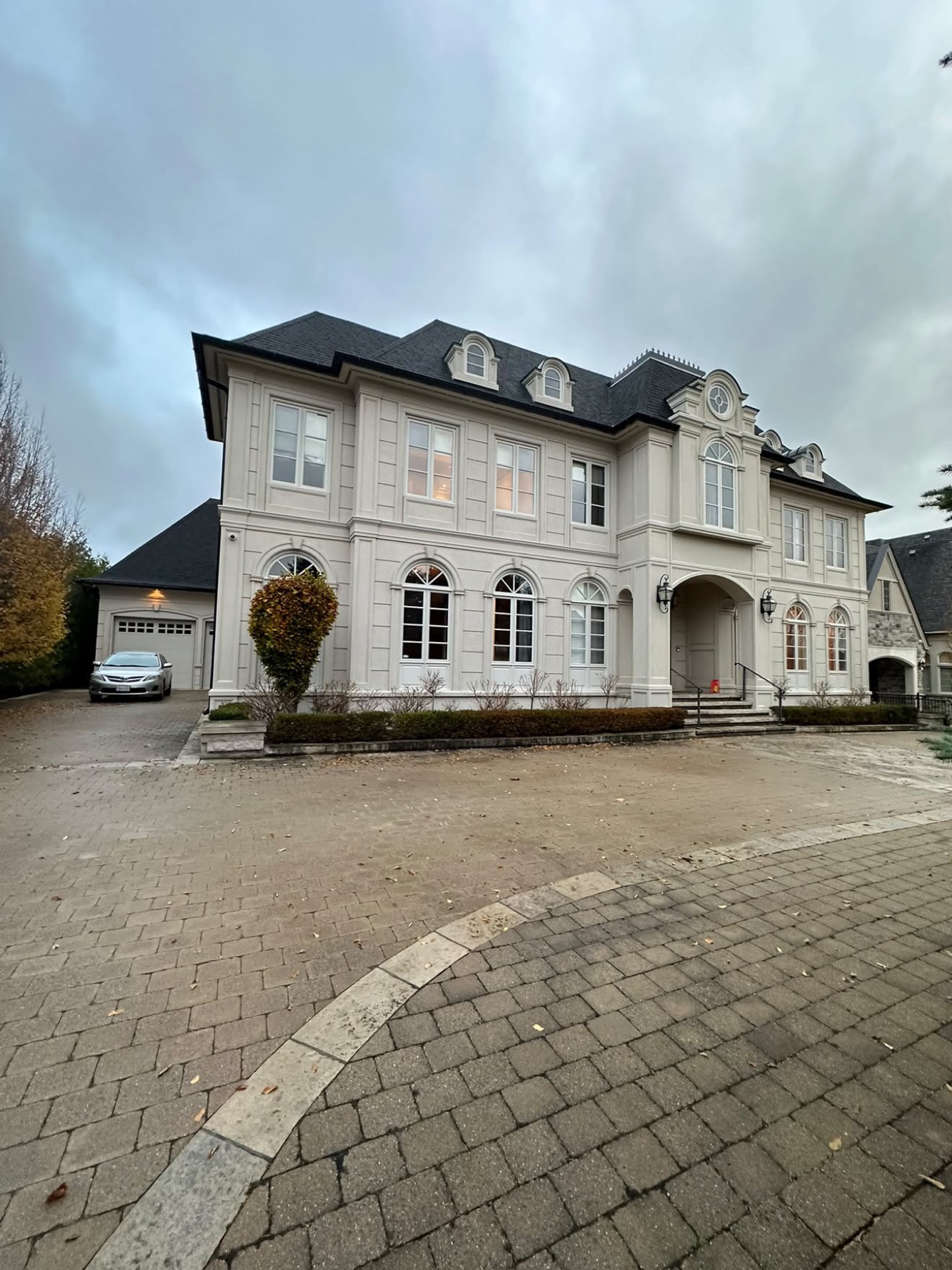 Façade d'une maison en pierre claire avec allée pavée